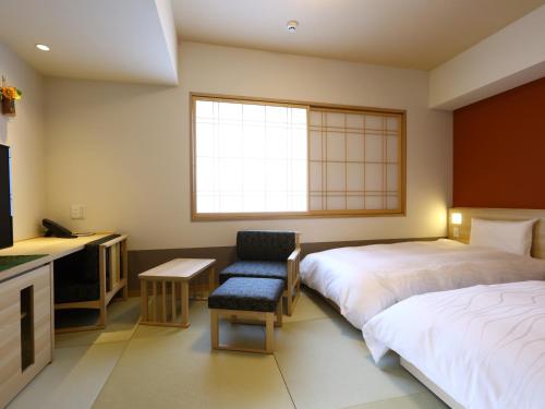 仙台Onyado Nono Sendai Natural Hot Spring的酒店客房,配有两张床和椅子