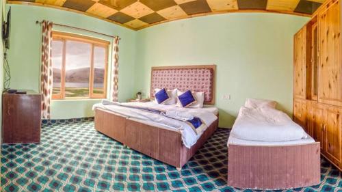 Karzok GömpaTsomoriri Hotel Lake View的一间卧室设有两张床和窗户。