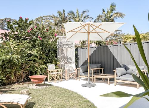 浅滩湾Casa Keys Shoal Bay的一个带椅子和遮阳伞的庭院