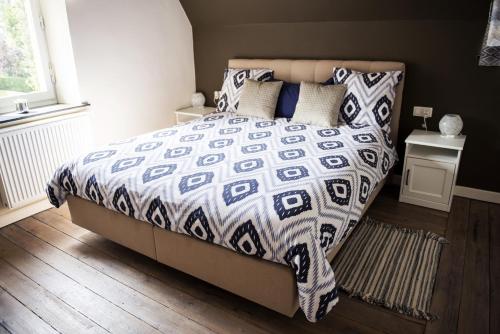 斯帕La Sentinelle Gite的卧室内的一张带被子和枕头的床