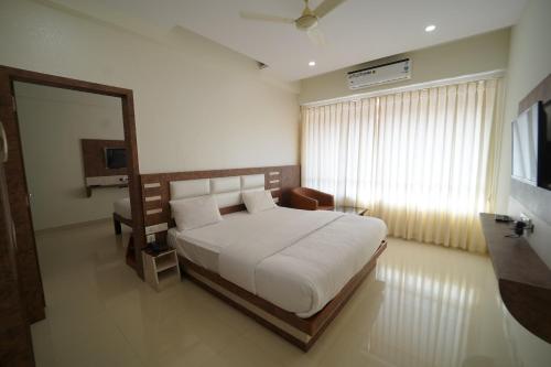 SubrahmanyaBhramari Nest的卧室配有一张白色大床和镜子