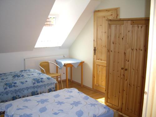 MünchhausenLandgasthof Zur Linde的一间卧室设有两张床、一张桌子和一个窗口。