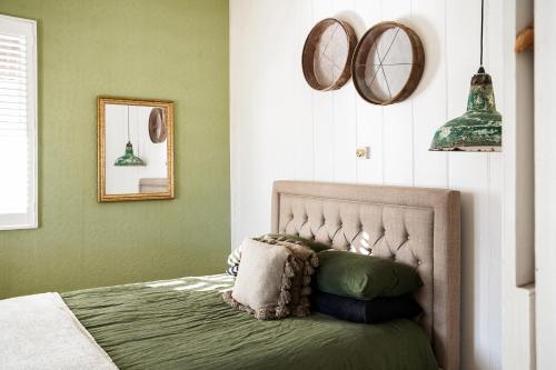 滕特菲尔德Mill Cottage的一间卧室配有一张带绿色墙壁和镜子的床
