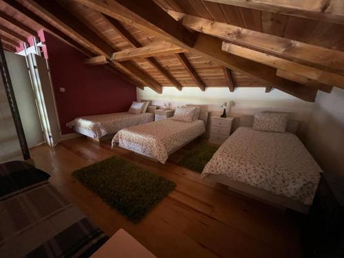FreixoO Celeiros的客房设有两张床和带横梁的天花板。