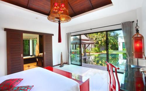 卡马拉海滩The Bell Pool Villa Resort Phuket的一间卧室设有一张床和一个大窗户
