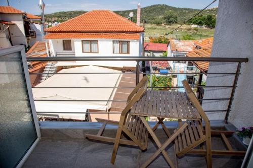 阿莫利亚尼岛elenamou seaview rooms的木椅,坐在带房子的阳台