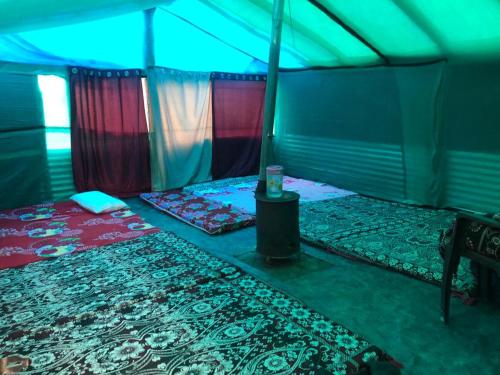 KheergangaCity Escape Camps and Cafe Kheerganga的帐篷配有两张床和一张桌子