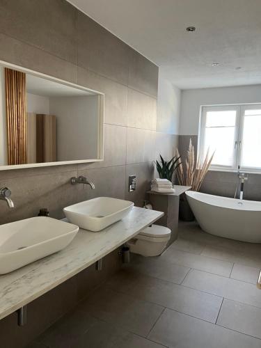 汉诺威Luxus Villa Hannover Messe的一间带两个盥洗盆、浴缸和卫生间的浴室