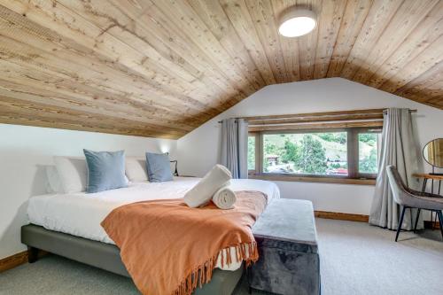 蒙特里永Hotel Du Lac的一间卧室设有一张大床和木制天花板