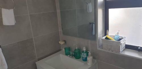 哈博罗内Sarona city Habitat Alpha apartments C202 Gaborone的浴室配有盥洗盆和带镜子的淋浴