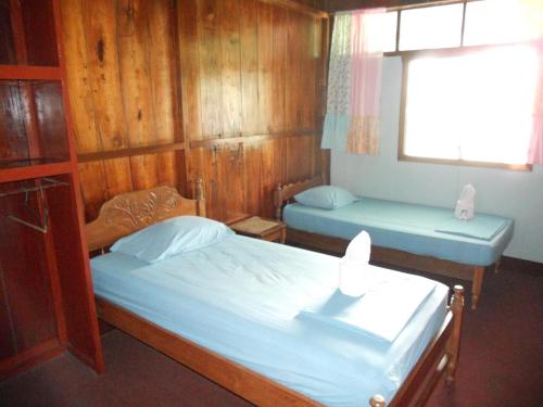 圣卡洛斯Cabinas Leyko的配有木墙和窗户的客房内的两张床