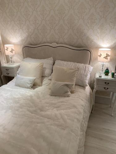 滨海纽比金Coastal Joy - Room 4的一张带白色枕头的白色床和2个床头柜