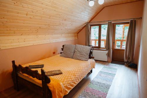 卢姆绍里Садиба над потоком的木制客房内的一间卧室,配有一张床