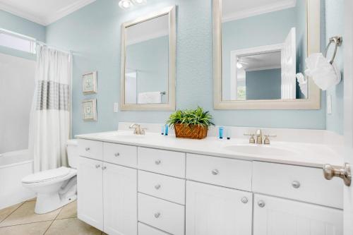 德斯坦Serenity的浴室设有2个盥洗盆、卫生间和2面镜子。