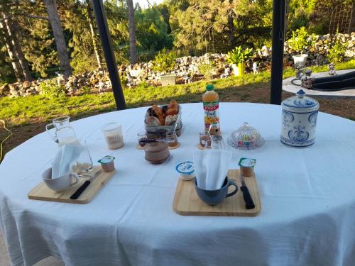 Celles-sur-BelleCHEZ VIVIANE的一张桌子,上面有白色的桌布,上面有杯子和餐具
