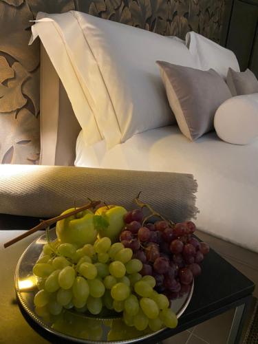 蒂拉诺DIMORA1934 Relax&Comfort的一张桌子上一盘葡萄,床边