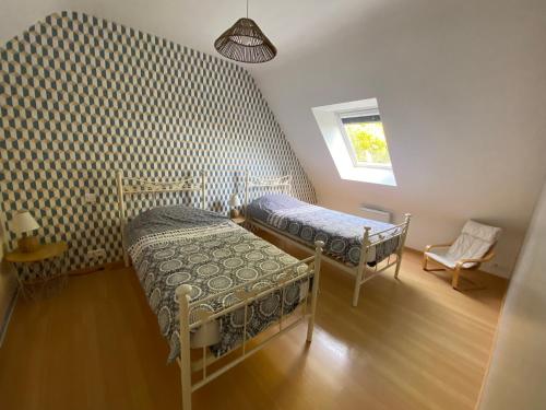 圣库隆Maison de vacances l’Émeraude的一间卧室设有两张床和窗户。