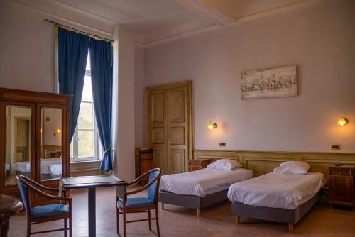 提韩格多迈纳都香格里拉诺伊维尔雍怡酒店的一间卧室配有两张床和一张桌子及椅子