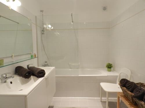 布鲁日圣安娜公寓的白色的浴室设有浴缸、水槽和浴缸。