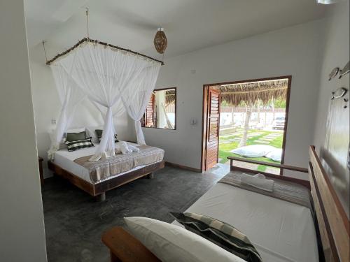 普雷亚Vila Bless 4 bedroom Vila with pool, garden and beach tennis court的一间卧室设有两张床和窗户。