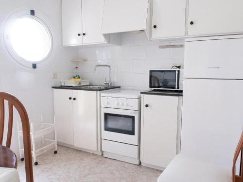 圣卡洛斯拉腊皮塔Agusti Hostal的厨房配有白色橱柜和白色冰箱。