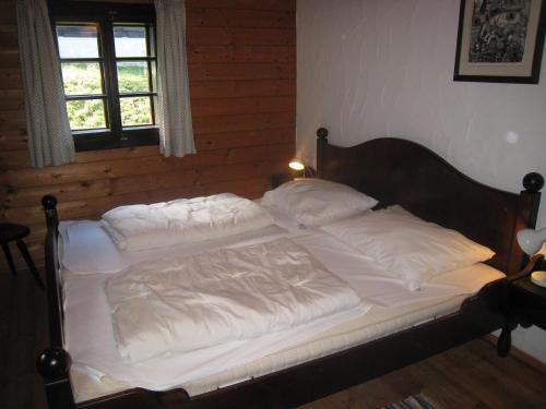 索内纳尔佩·纳斯费尔德Schiappartement Nassfeld的卧室内的一张带白色床单和枕头的床