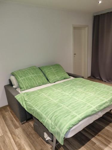 沃尔夫斯堡Maria Apartment的一间卧室配有一张带绿色棉被的床