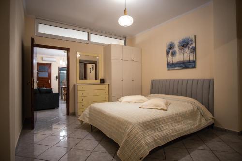 萨摩斯Ariadni Luxury Apartment的一间卧室配有一张床、梳妆台和镜子