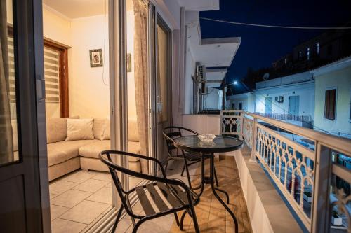 萨摩斯Ariadni Luxury Apartment的阳台配有桌椅和沙发。