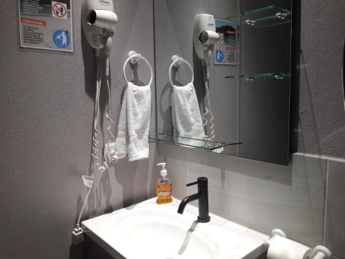 奎波斯城Apartamentos Mansión Tropical的一间带水槽和镜子的浴室