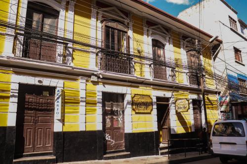 拉巴斯Wake Up Hostel的街道边的黄色和白色建筑