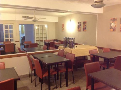 罗萨里奥米特里酒店的餐厅用餐室配有桌椅