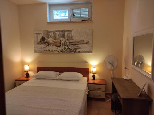 梅杜林Nice-Comfort-Lux Apartment 95m2 near the beach的一间卧室配有一张床和一张带两盏灯的书桌。