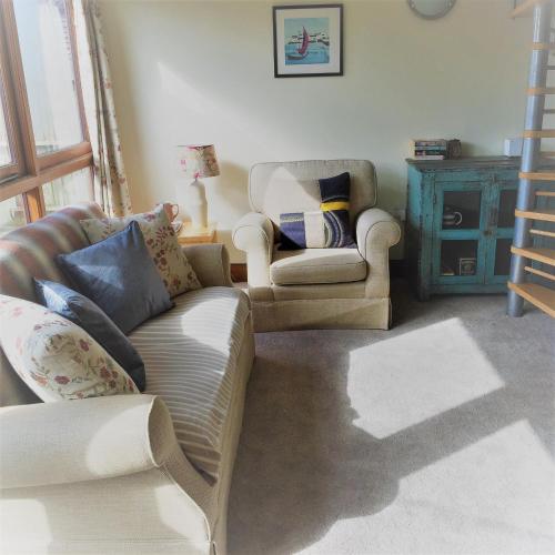 汤顿Meg's Cottage的客厅配有沙发和两把椅子