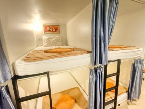 乔木提恩海滩Jomtien Beach Hostel的小房间,设有床和梯子