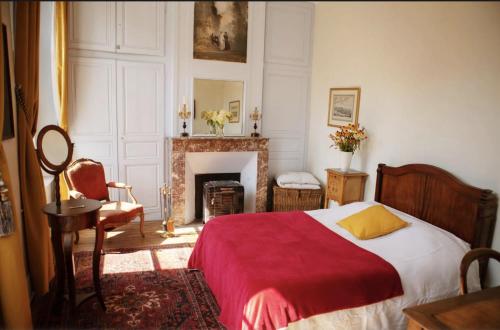 Bouillancourt-en-SéryChâteau de Bouillancourt en Sery的一间卧室配有一张带红色毯子的床和一个壁炉