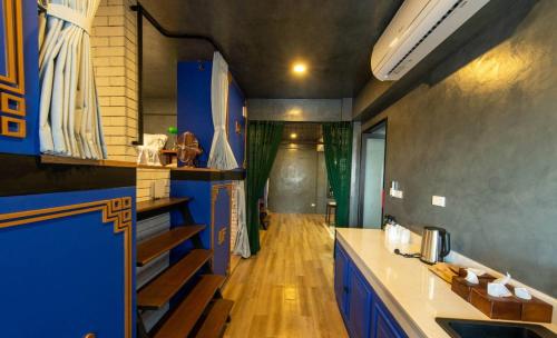 合艾Lynlan Hostel & Cafe的厨房铺有木地板,配有蓝色橱柜。