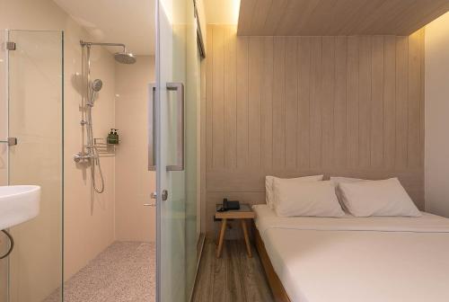 曼谷水门皮瑞德酒店的小型浴室设有一张床和淋浴。