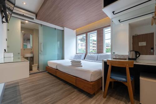 曼谷水门皮瑞德酒店的一间带一张床和一张书桌的卧室和一间厨房