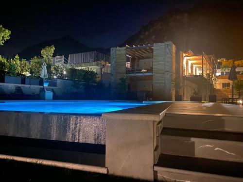 利莫内-苏尔加达Sibenbras Natural Aparthotel的一座游泳池,晚上与大楼相连