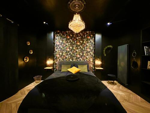 昂热Love Room Secrète Les Petits Plaisirs的一间卧室配有一张大床和一个吊灯。