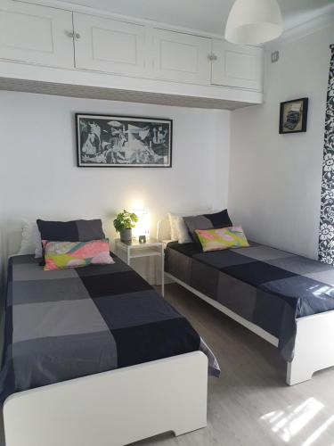 塞维利亚NOOL Sevilla的白色和黑色客房的两张床
