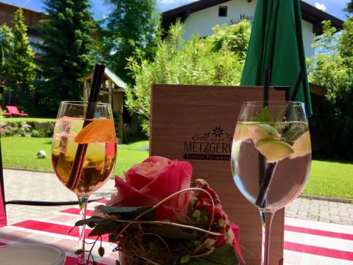蒂罗尔-基希贝格美思戈尔维尔特酒店的一张桌子,上面放着两杯葡萄酒和一碗鲜花