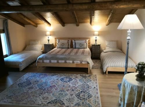 扎费拉纳-埃特内阿费多阿尔吉拉兹度假屋的一间卧室配有两张床、一盏灯和一张地毯。