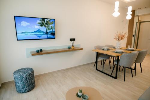 亚历山德鲁波利斯Magico Suites City Heart Luxury Appartments的客厅配有桌子和墙上的电视