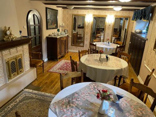 塔尔图Vikerkaare Villa的一间带2张桌子和壁炉的用餐室