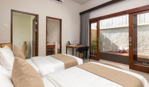 龙目岛库塔KU Villas的酒店客房设有两张床和窗户。