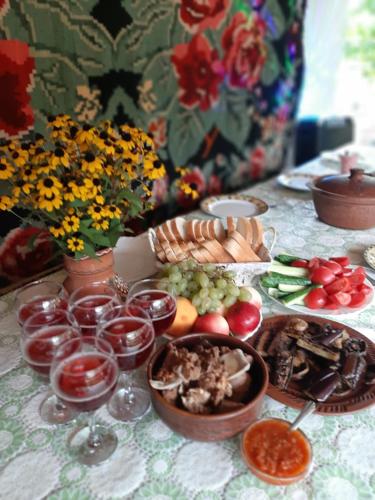 ChişcăreniPensiunea turistica "Casa rustica"的餐桌,带食物盘和酒杯