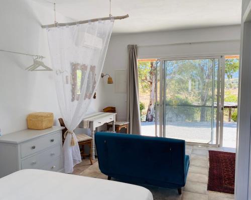 比纽埃拉La Rústica en Viñuela, piscina privada的一间卧室配有一张床、一张书桌和一个窗户。
