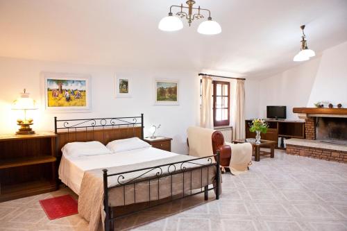 伊格莱西亚斯Casa vacanze Maria Maddalena 1 Iglesias的一间卧室设有一张床,客厅设有壁炉。